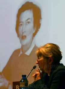 Mª José Casado en un momento de la conferencia. Mary Leakey al fondo. Credit: Izaskun Lekuona